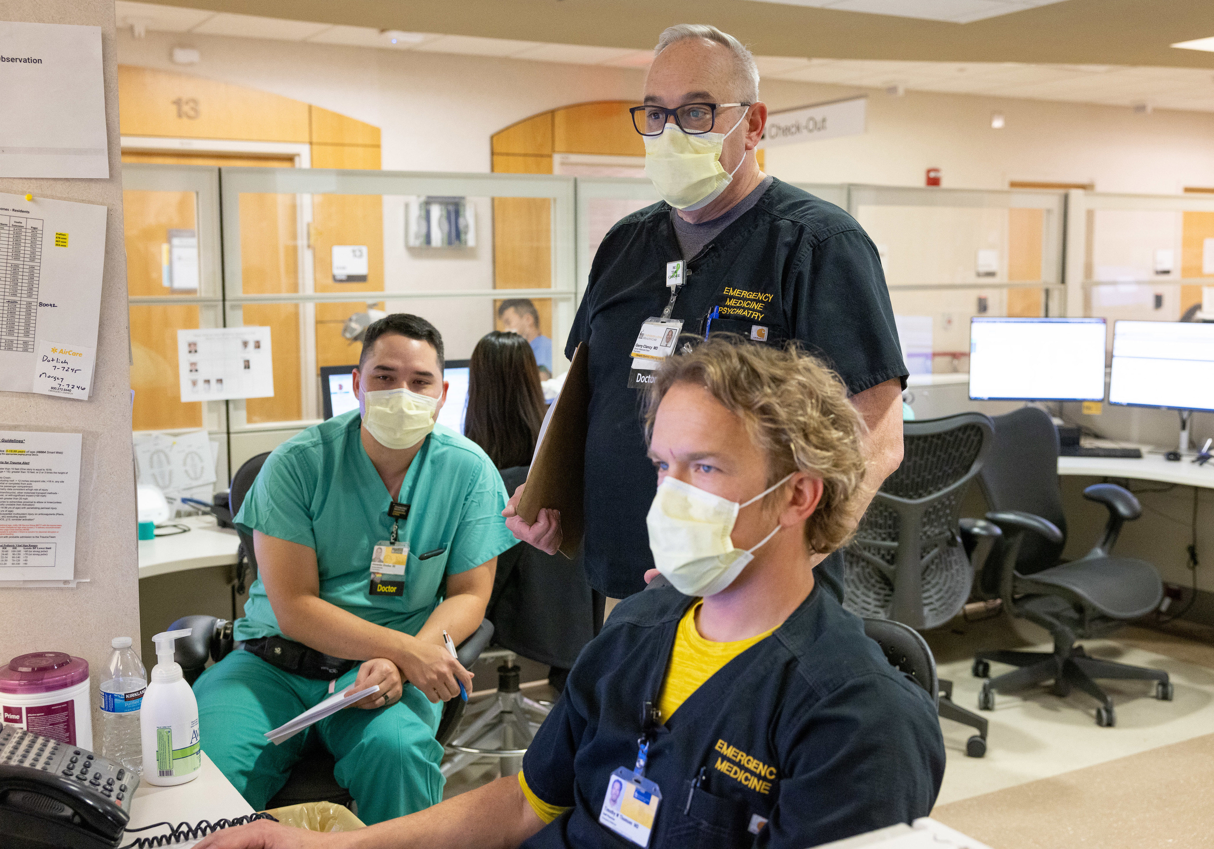 Dr. Gerry Clancy confers with colleagues, including emergency medicine physician Timothy Thomsen, in the Emergency Department on Tuesday, December 6, 2022. Clancy hosts a podcast Rounding@Iowa as well as a new program called THRIVE that offers leadership skills sessions to early-career faculty.