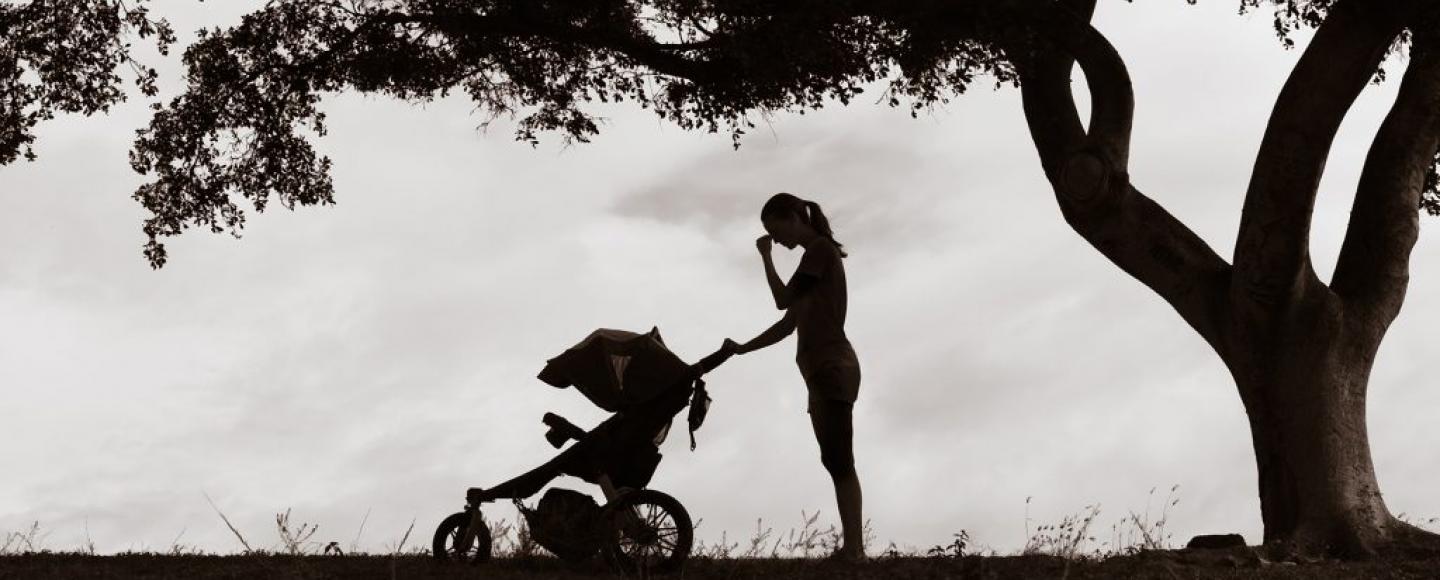 silhouette of woman pushing a baby stroller