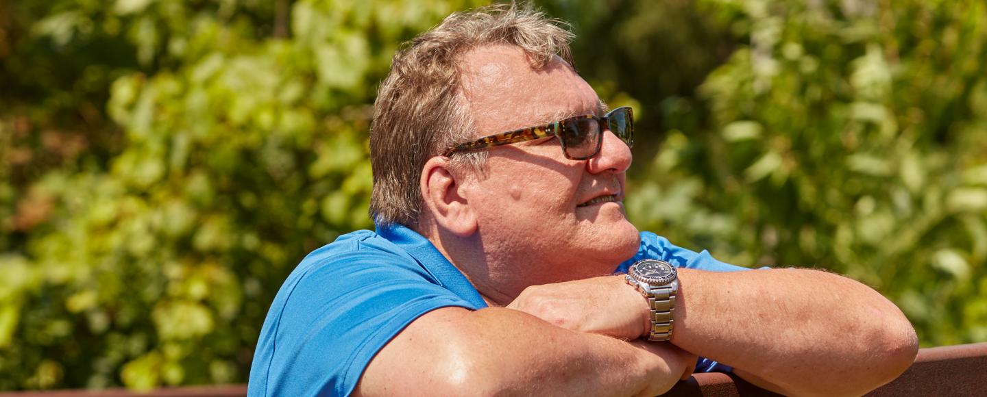 man leaning over a fence