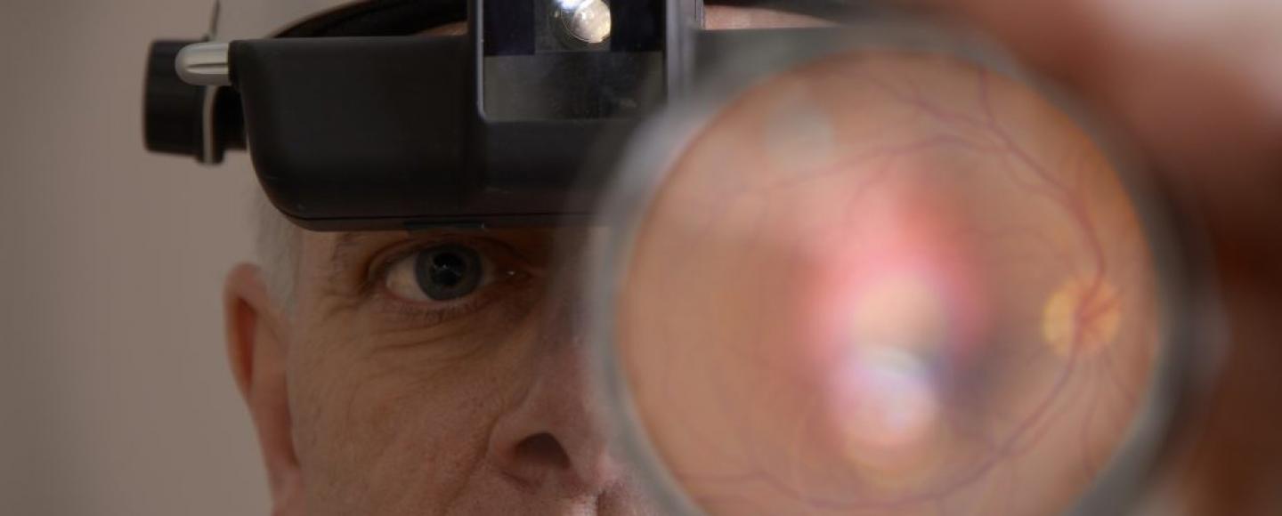 image of doctor examine an eye through a magnifer
