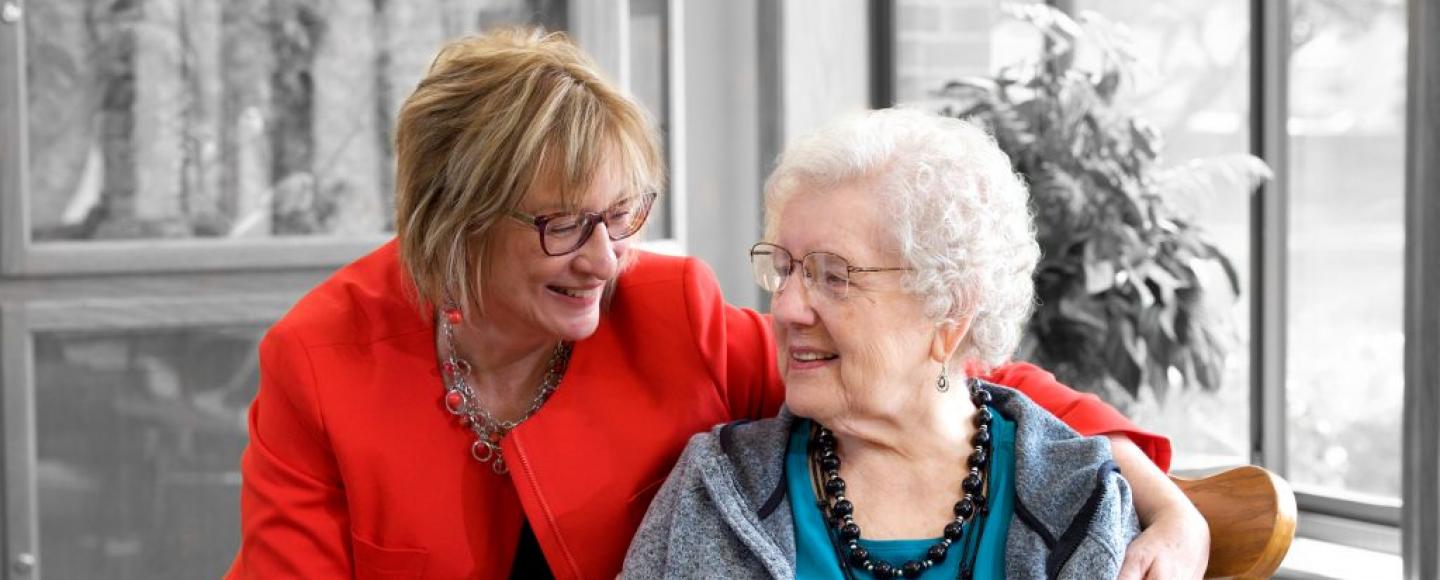 caretaker with arm around an elderly woman