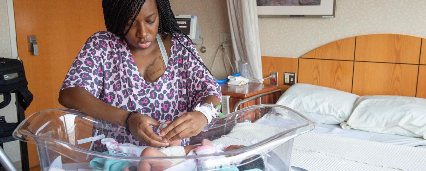Aquarius Bunch tends to her newborn child in the hospital