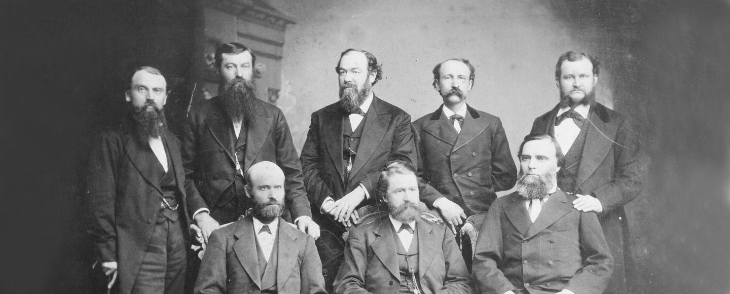  A black and white photograph of a group of men from the 1800s with the caption 'Time Capsule Budaya 1990an'.