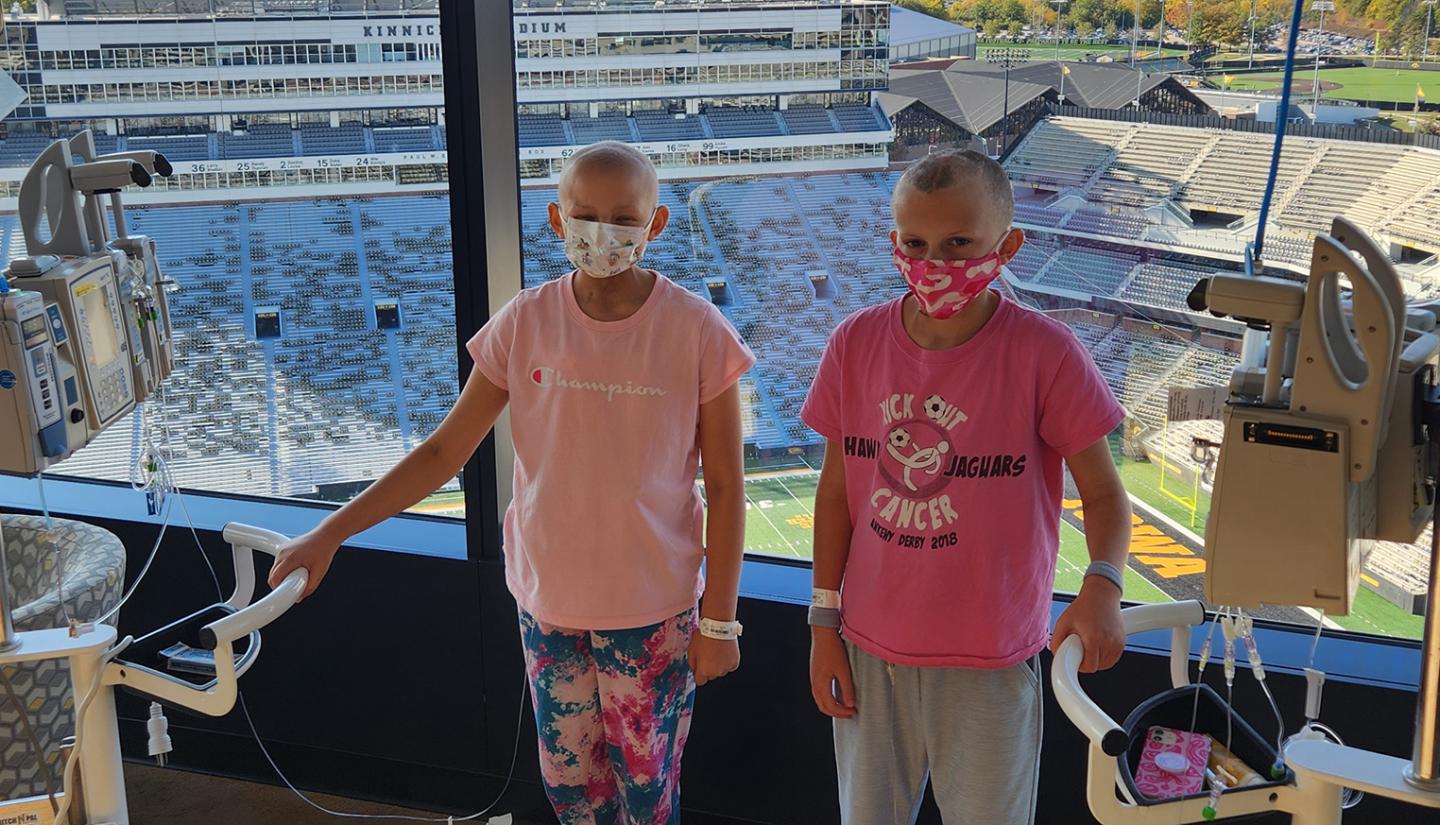 Bella and Harper standing near window at University of Iowa Stead Family Children's Hospital