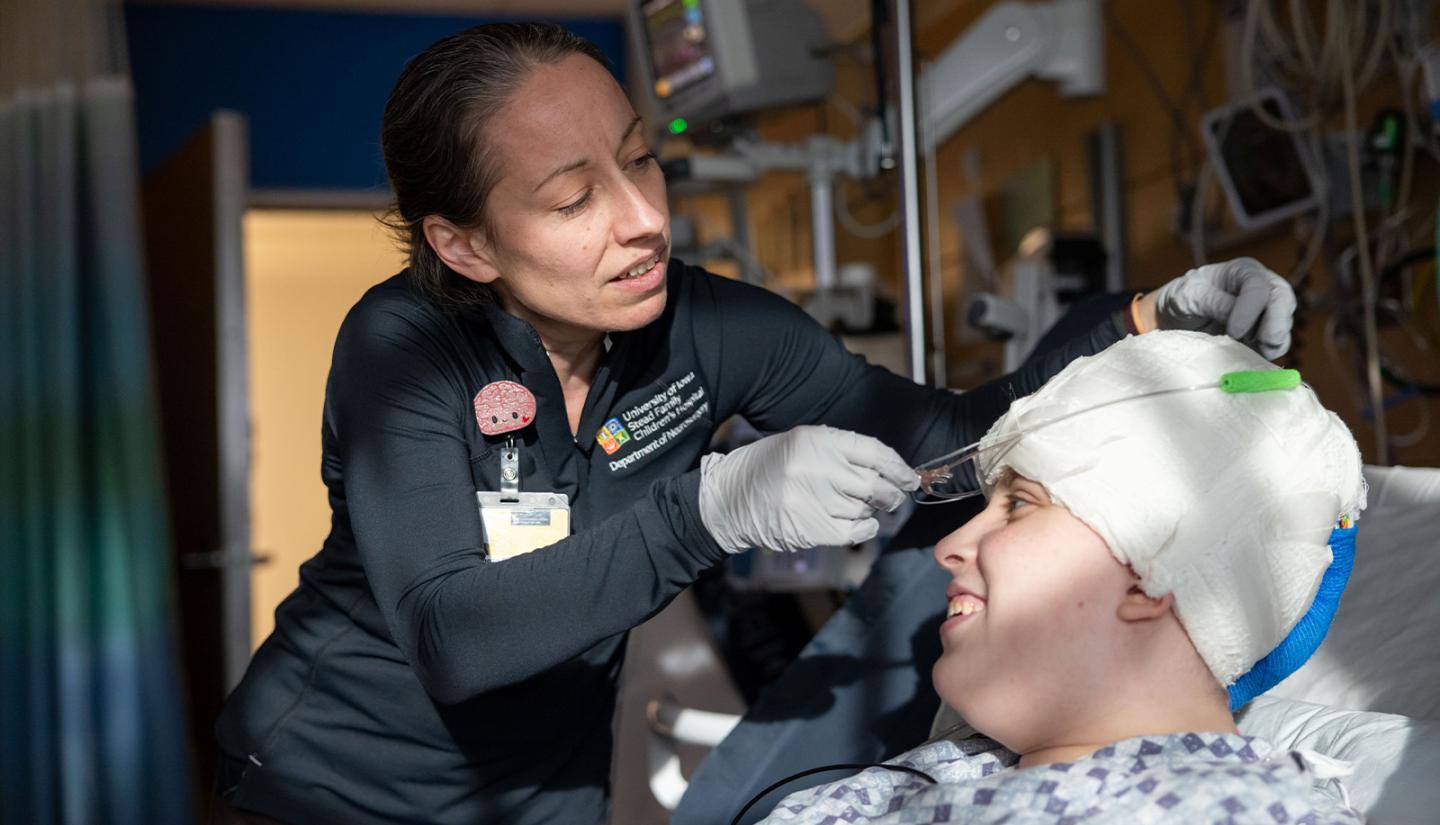 Ariane Rhone, PhD, associate research scientist in the UI Department of Neurosurgery, attaches a respiration monitor to a patient at UI Stead Family Children's Hospital.