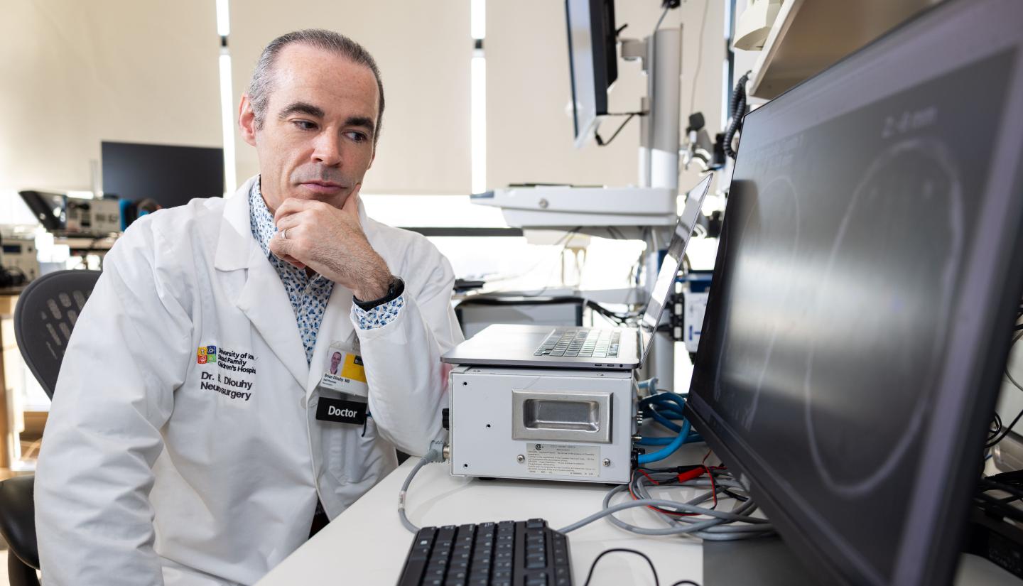 Brian Dlouhy, MD, looking at a computer screen in his laboratory
