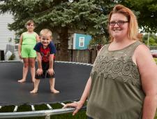 a woman with her kids on a trampoline
