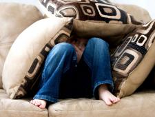 image of boy hiding under pillows