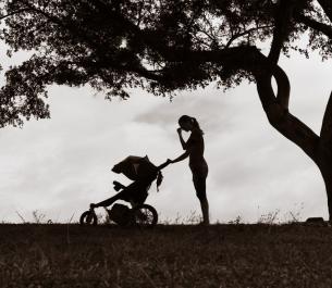 silhouette of woman pushing a baby stroller