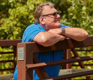 man leaning over a fence