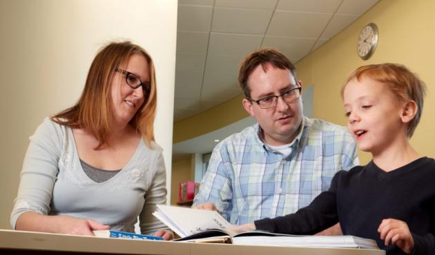 two parents and child reading