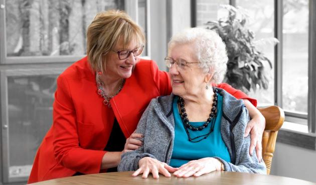 caretaker with arm around an elderly woman