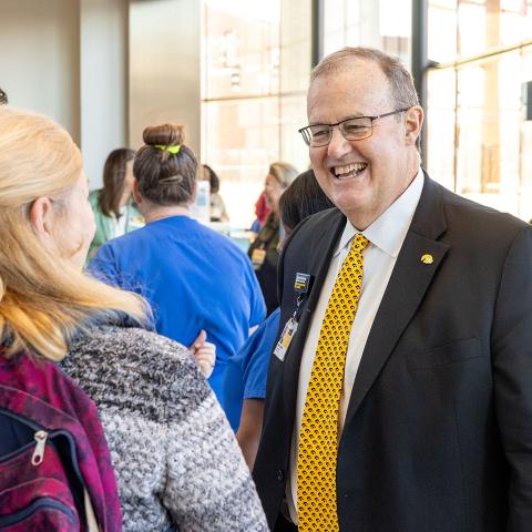 Haws speaks with woman at staff lunch